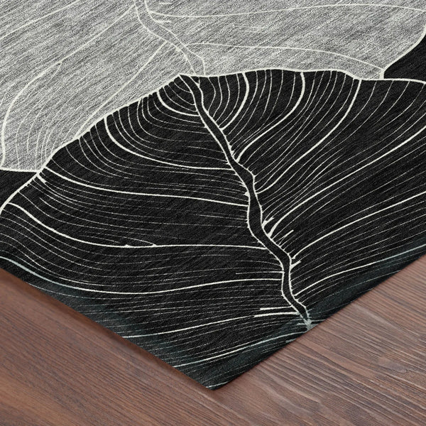 Black and white leaf-patterned rug, woven with thick fibers, perfect for modern home decor.