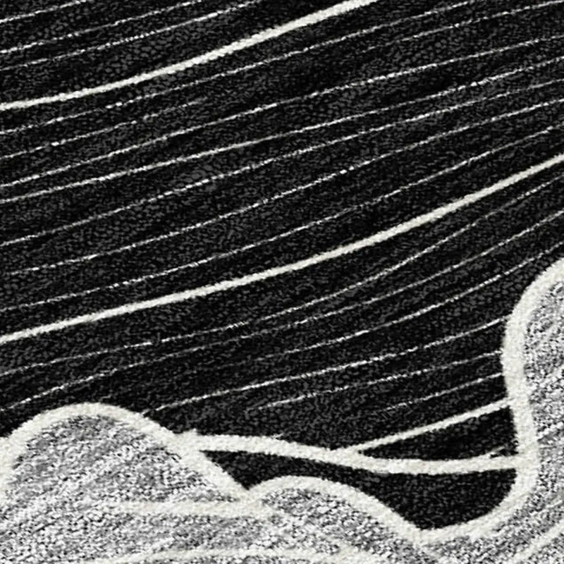 Black and white abstract area rug, featuring wavy lines and a textured, plush finish, perfect for modern decor.