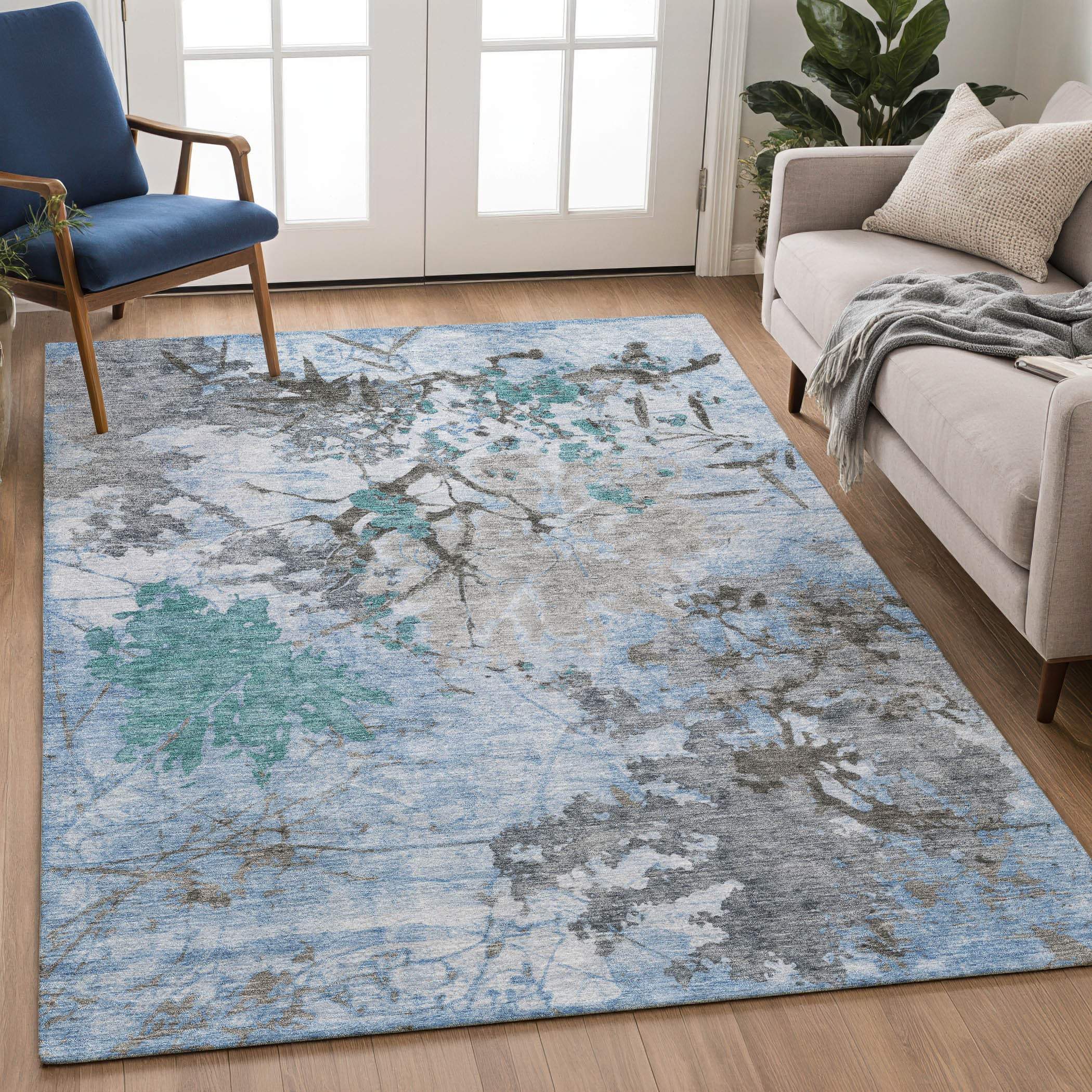 Blue floral patterned area rug with gray accents, made of soft, durable material, ideal for modern living spaces.
