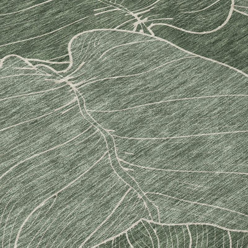 Green woven area rug with large white leaf patterns, perfect for a modern, nature-inspired decor.