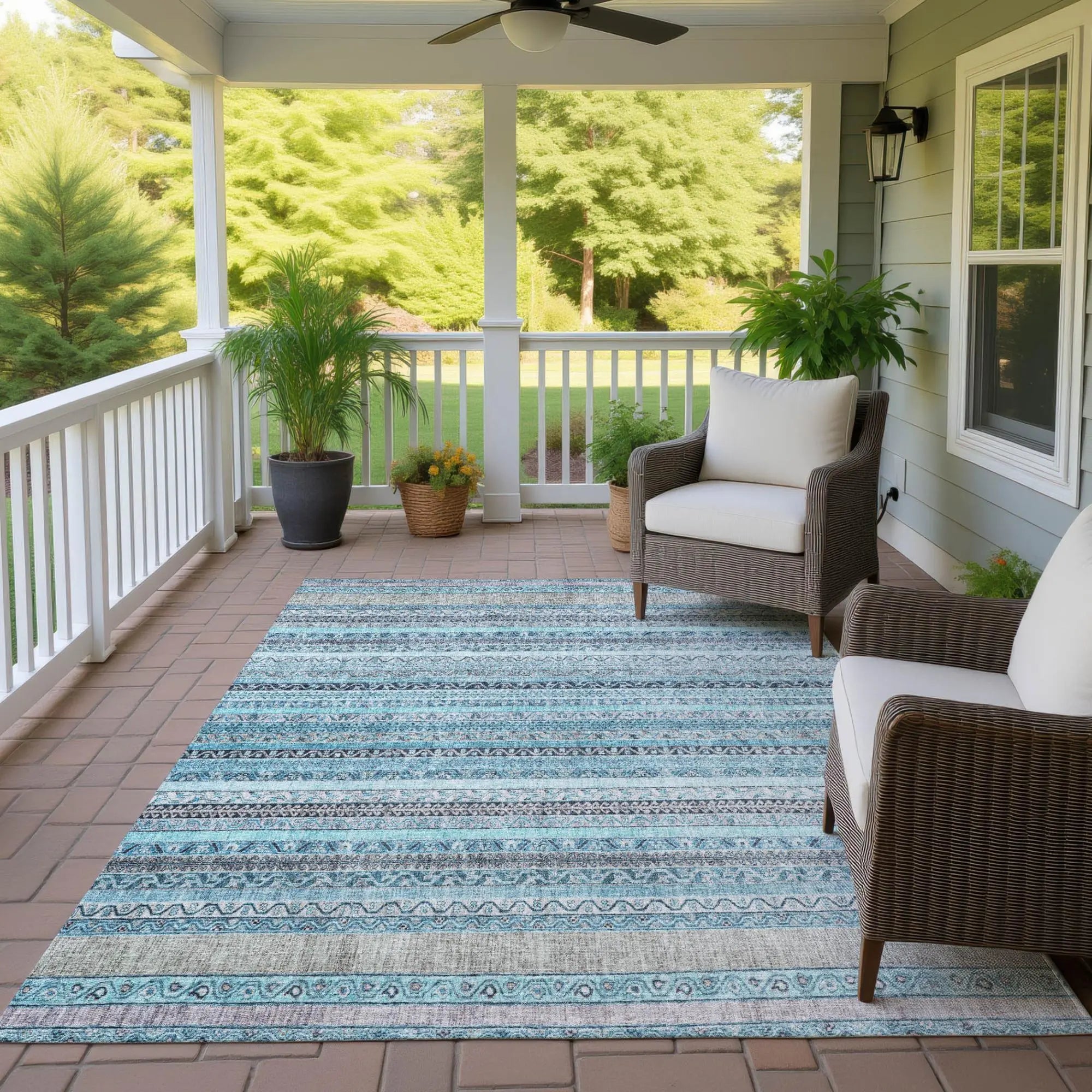 Blue and gray striped outdoor rug in woven texture, perfect for porches or patios. Durable and stylish.