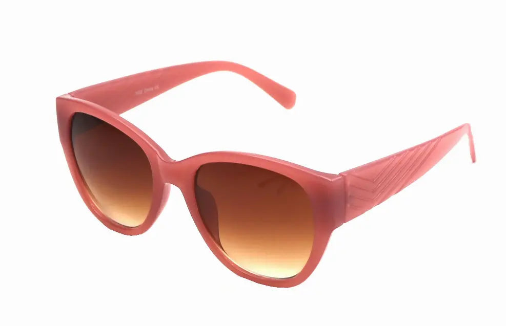 Pink oversized cat-eye sunglasses with gradient brown lenses and textured detailing on the arms.
