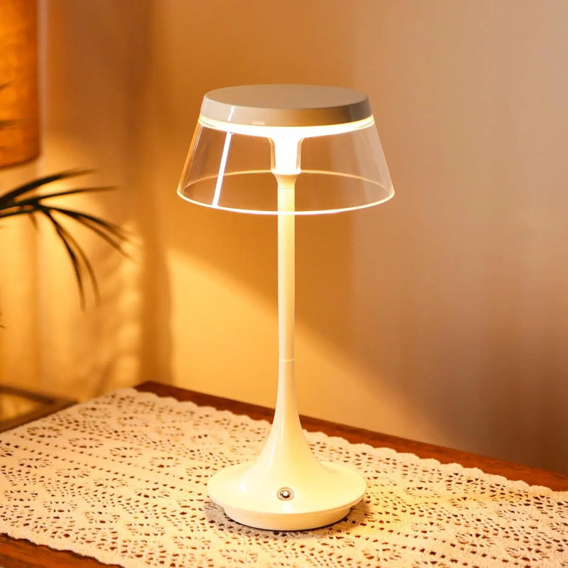 Modern white table lamp with a clear shade, featuring a sleek design and a soft, warm glow. Ideal for home decor.