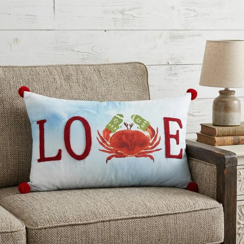 Red crab-themed lumbar pillow with "LOVE" lettering, white fabric, and red pom-pom accents, perfect for coastal decor.