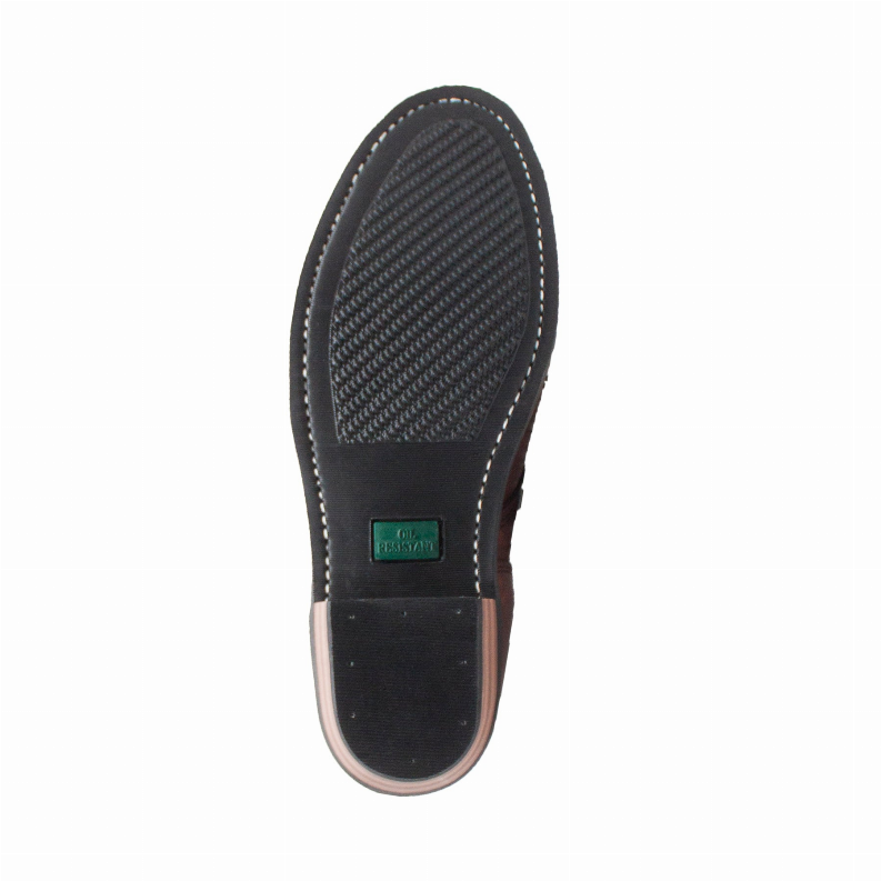 Textured boot outsole underside with black tread and green label on footbed