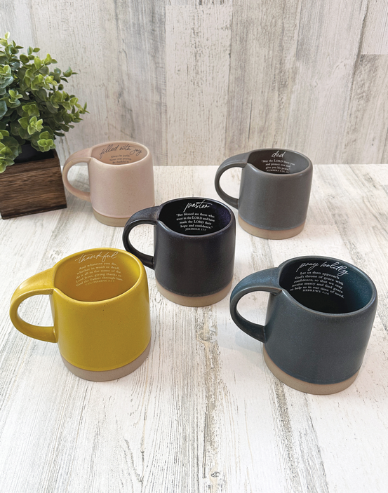 Ceramic mugs with inspirational quotes in yellow, pink, dark gray, and black colors