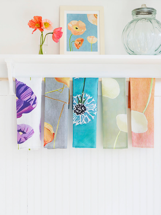 Set of tea towels: purple, aqua floral, peach, and teal patterns on a clothesline