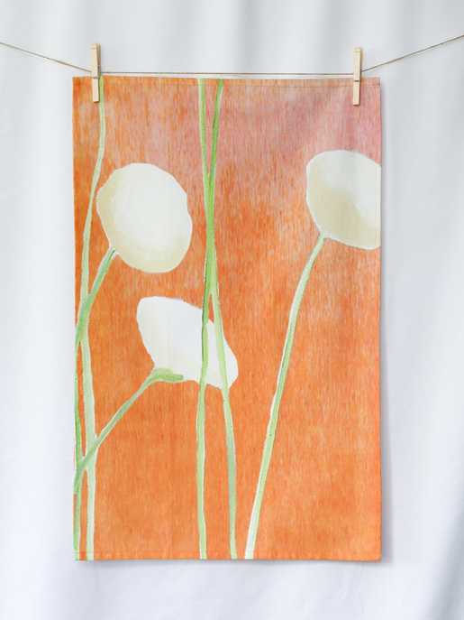 Orange tea towel with large white flowers and green stems