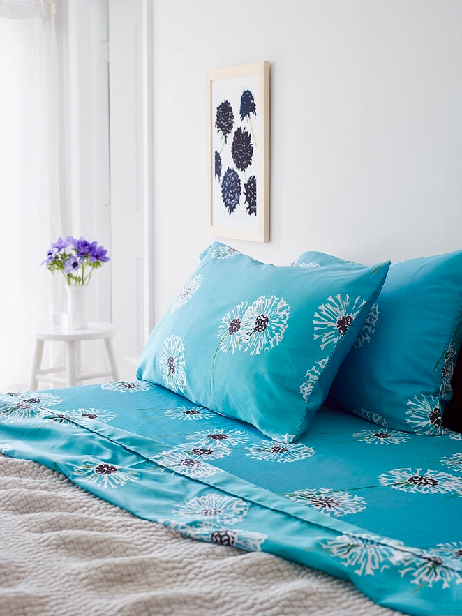 Turquoise bedding set with white floral burst pattern, fitted sheet and pillowcases