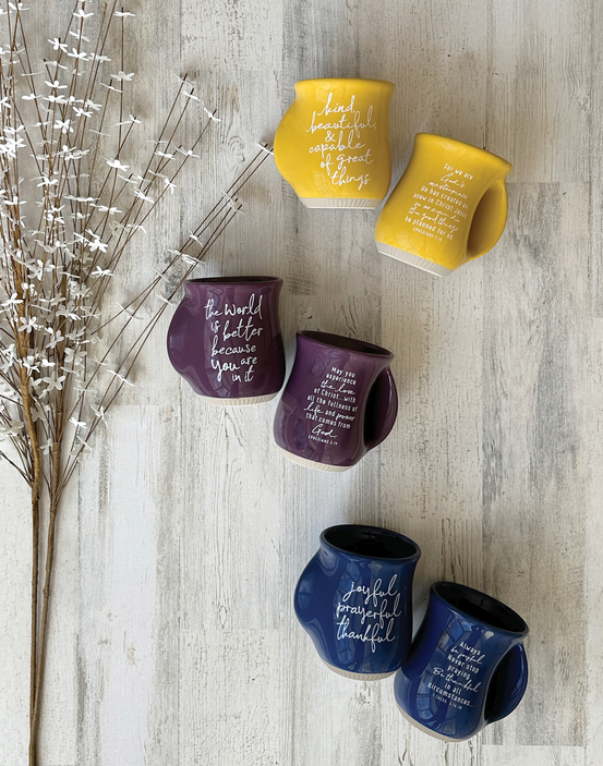 Prayerful handwarmer mugs in navy, purple, and yellow with inspirational lettering