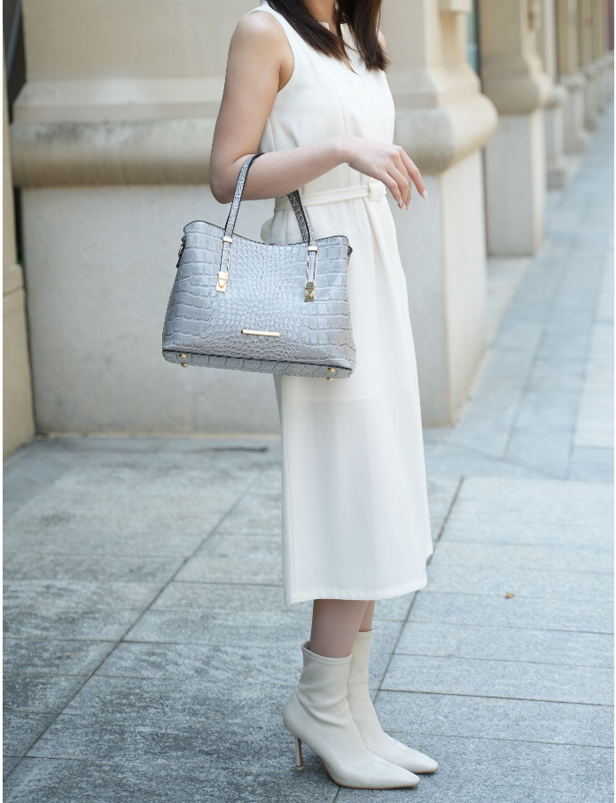 Crocodile-embossed vegan leather tote bag in gray, carried by two top handles