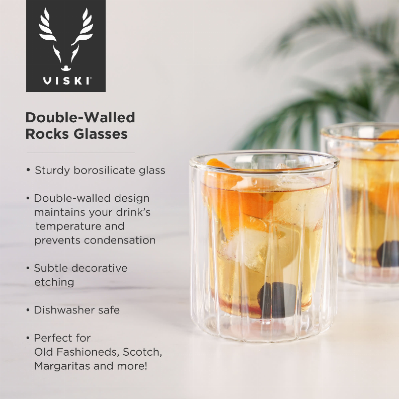 Double-walled rocks glass, clear borosilicate with amber drink and ice cubes visible