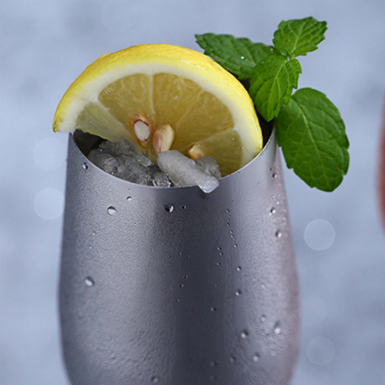 Stainless ice bucket with lemon half, ice cubes, and fresh mint leaves