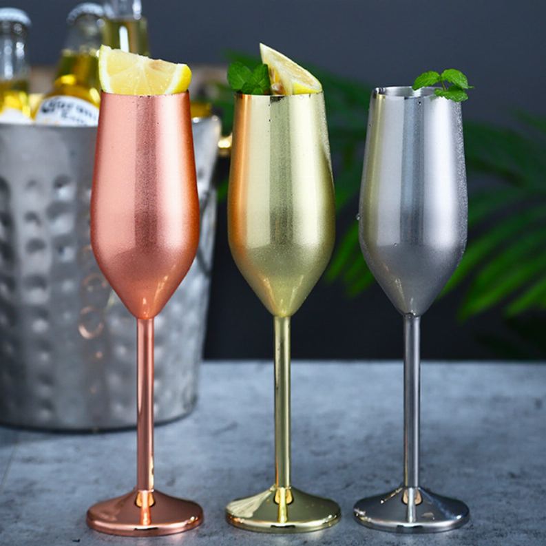 Metallic cocktail glasses in rose, gold, and silver with lemon wedge and mint