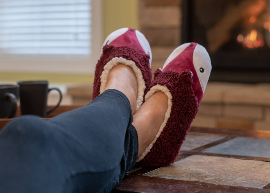 Fox plush slippers on feet, maroon fuzzy exterior with white soles and lining