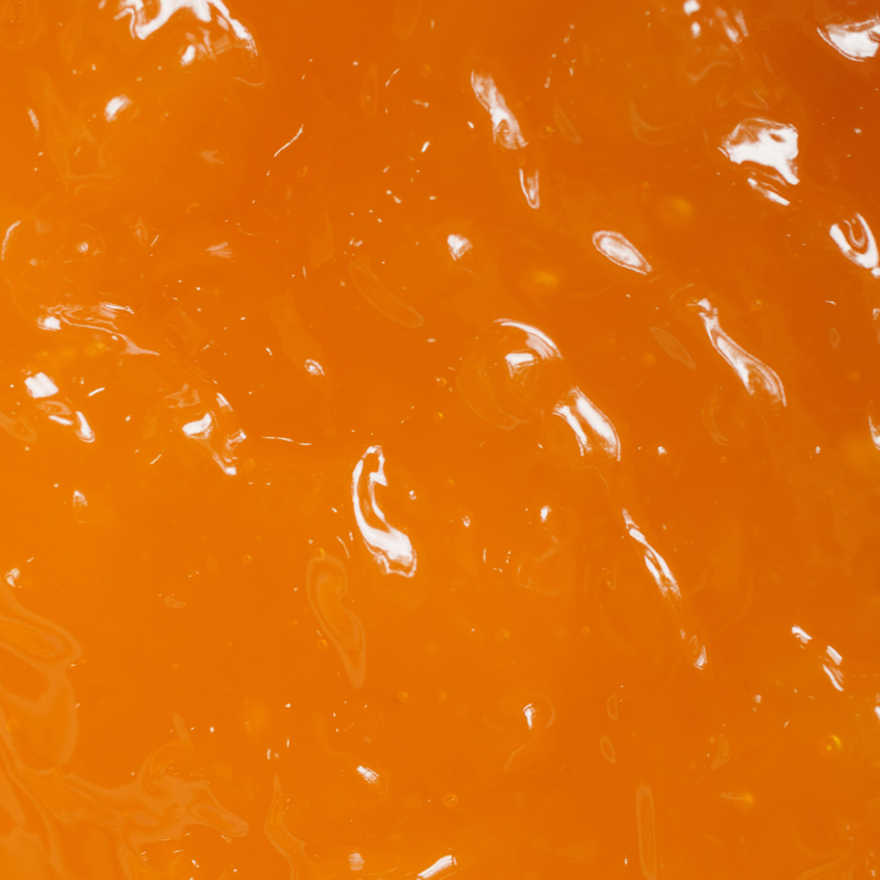 Glossy orange wax surface with swirling highlights.