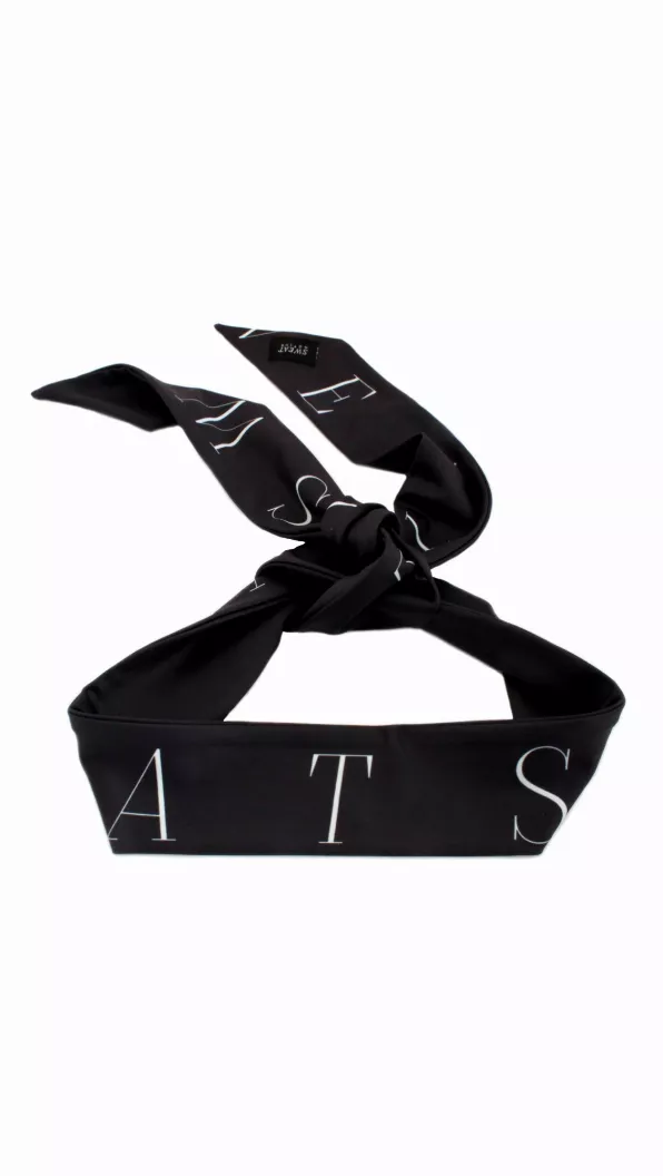 Black headtie laid flat with light geometric lettering