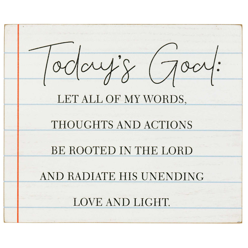 Tabletop plaque close-up: 'Today's Goal' quote text on blue-lined background with frame