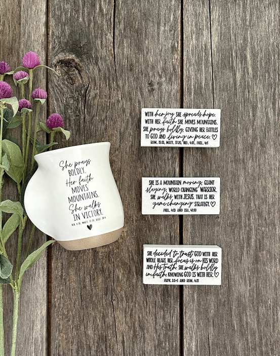 White ceramic prayer bowl with black handwritten scripture verses on wooden surface