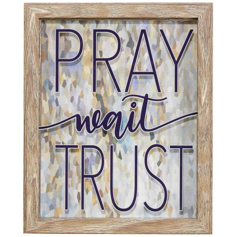 Wood framed wall art with 'PRAY wait TRUST' lettering on patterned background