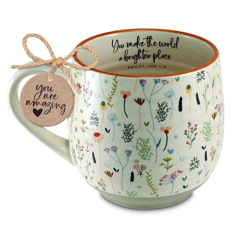 Floral ceramic coffee mug with green rim; charm tag tied to the handle