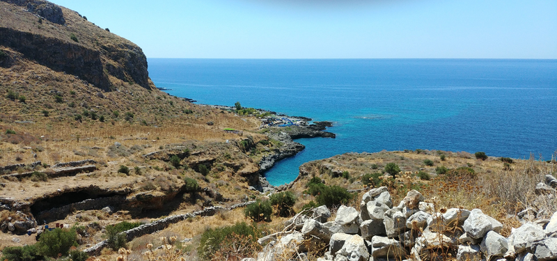 Rocky coastal shoreline overlooking the blue sea, salt harvesting scene