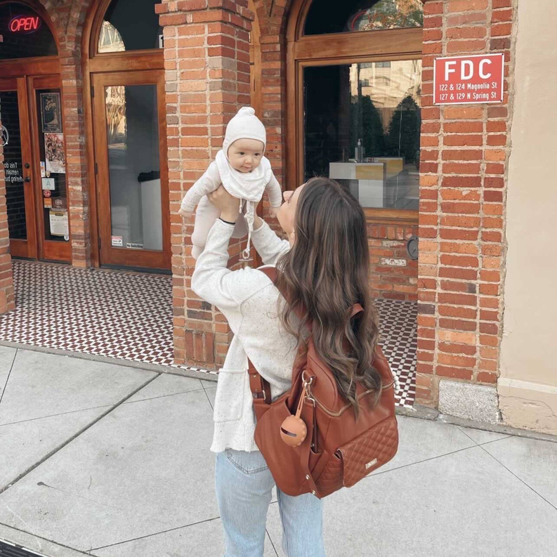 Caramel brown diaper bag backpack with adjustable straps and front zip pocket