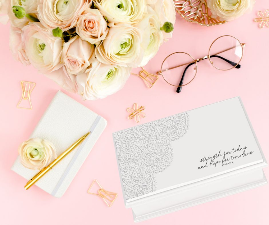 White keepsake box with lace floral design and script on lid, closed