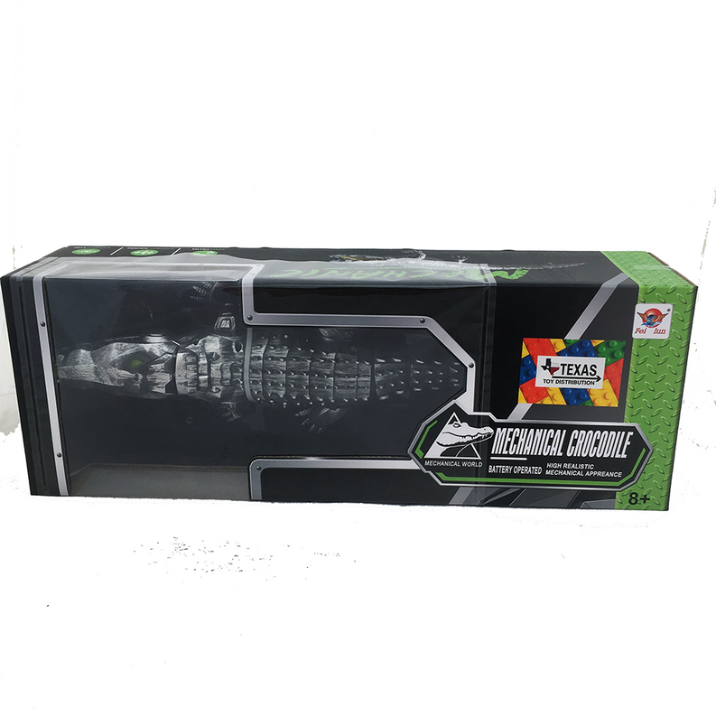 Mechanical walking crocodile toy in retail box, dark silver body with yellow accents.