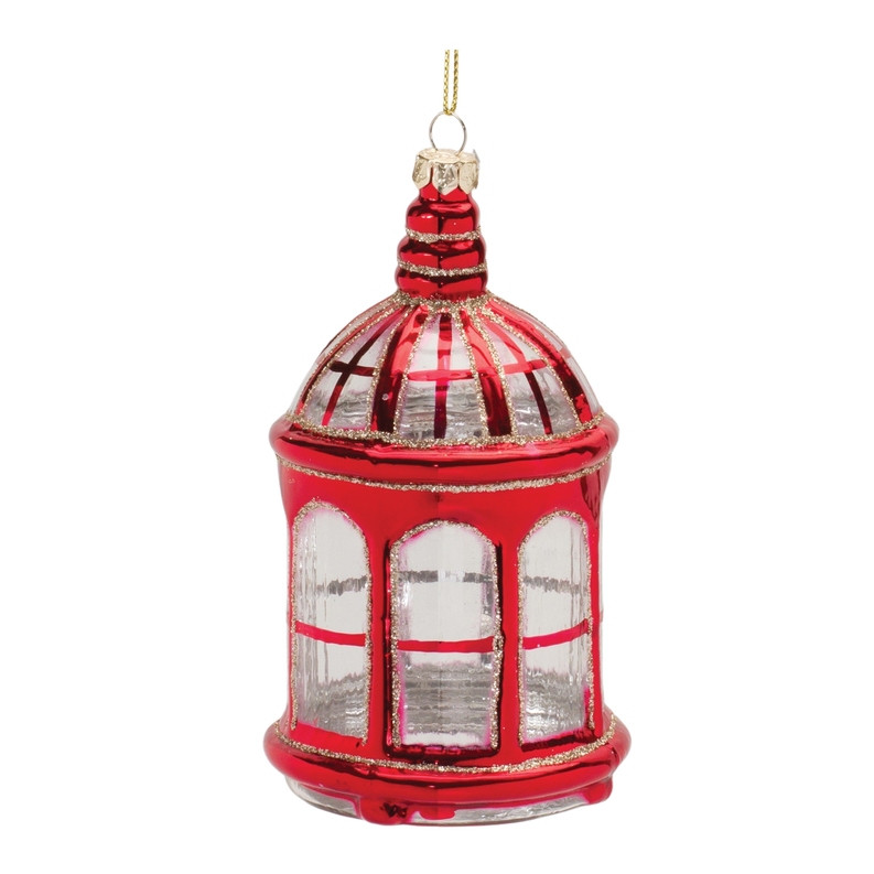 Red glass lantern ornament close-up with gold top loop and arched window panels