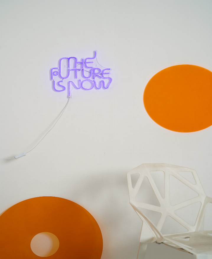 Violet LED neon sign reading 'THE FUTURE IS NOW' with power cord