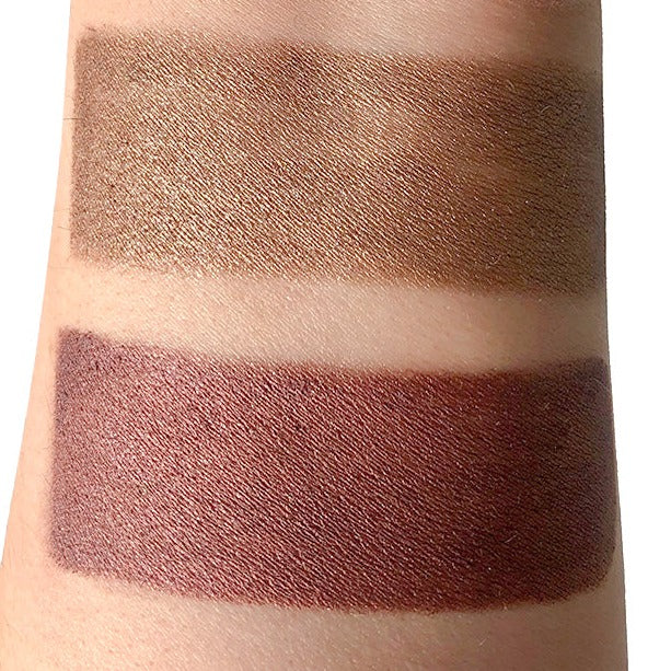 Arm swatch of shimmery bronze-brown eyeshadow and layered maroon shade
