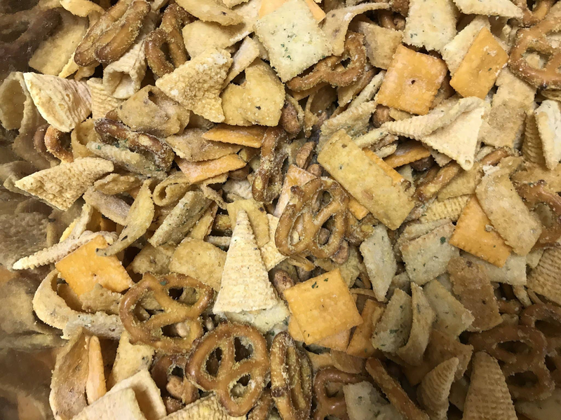 Close-up of seasoned pretzel pieces and crumbs in brown, tan, and orange