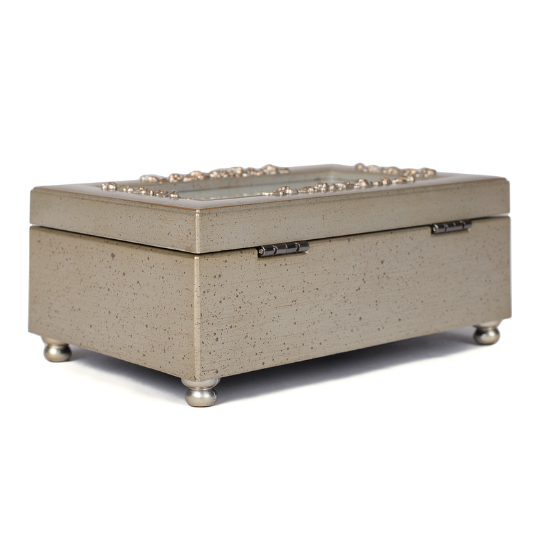Speckled beige music box with ornate clasp and small gold feet
