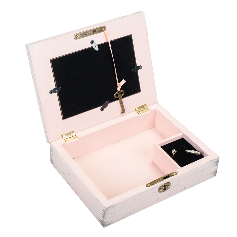 Opened pink wooden music box with black soundboard, gold hardware, and brass hinges.
