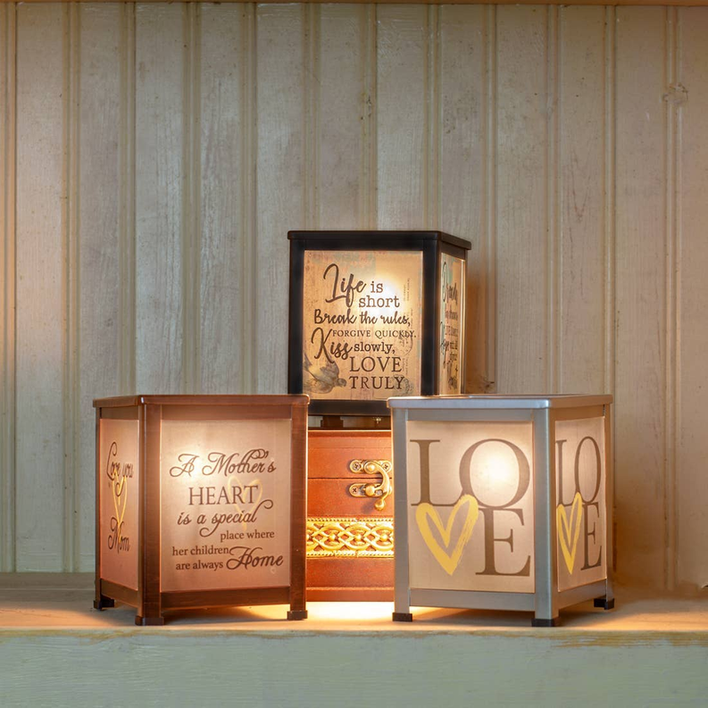 Set of glass lantern warmers on a shelf in black, tan, and gray