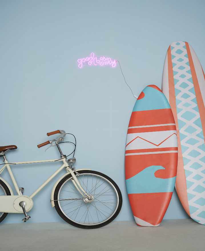 Pink LED neon sign with cursive “Good Vibes Only” text, glowing.