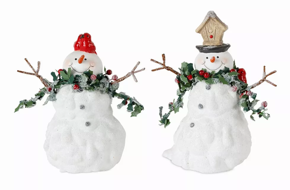White snowman figurines with red caps, green holly accents, and twig arms