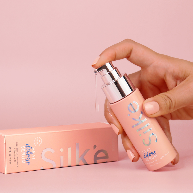 Silk'e Heat Defense Serum bottle with pump dispensing a small amount; box beside it