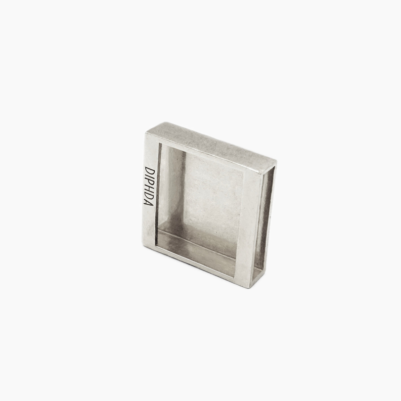 Silver moon charm back with an engraved mark inside the square frame