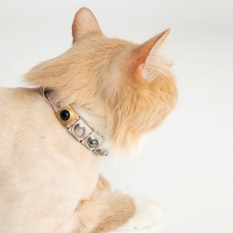 Close-up of a charm collar with rose quartz moon links and metal accents