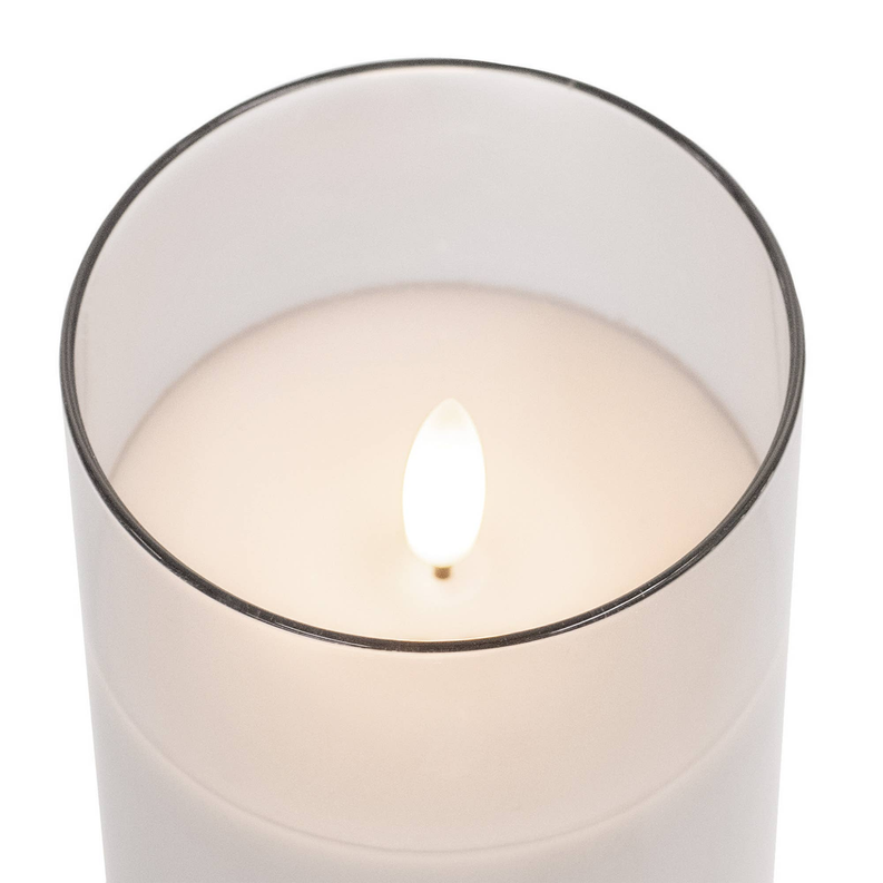LED candle top view: clear glass cup with white wax and glowing faux flame.