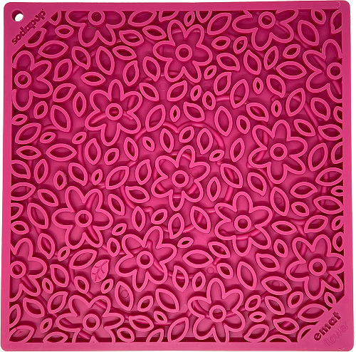 Pink rubber lick mat with raised flower shapes pattern, close-up