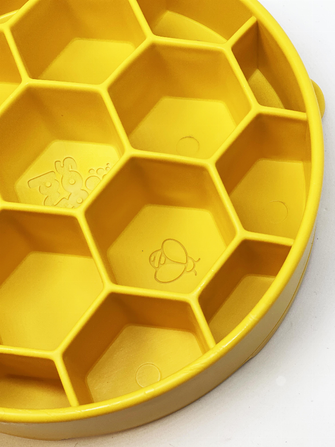 Close-up of yellow honeycomb slow feeder bowl interior with raised hex cells