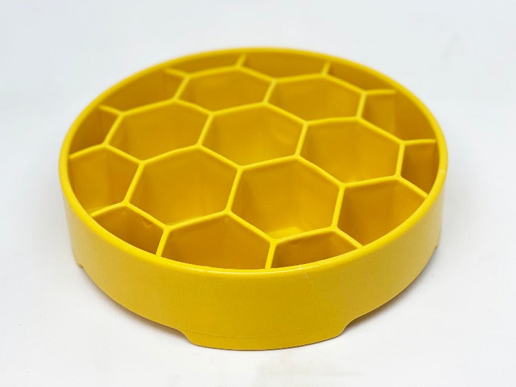 Yellow honeycomb slow feeder bowl with open top and hex compartments, empty
