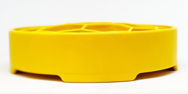 Yellow honeycomb slow feeder bowl, side view showing raised base and hex rim