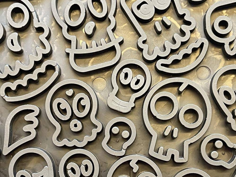 Close-up of raised zombie-face shapes on dark rubber lick mat surface