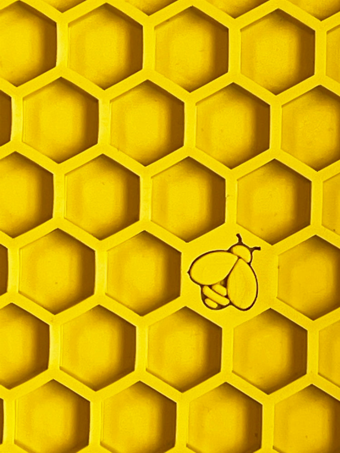 Close-up of yellow honeycomb rubber texture with raised paw icon