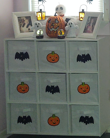 Large Halloween foam cut-outs on cabinet doors, including pumpkins and bats