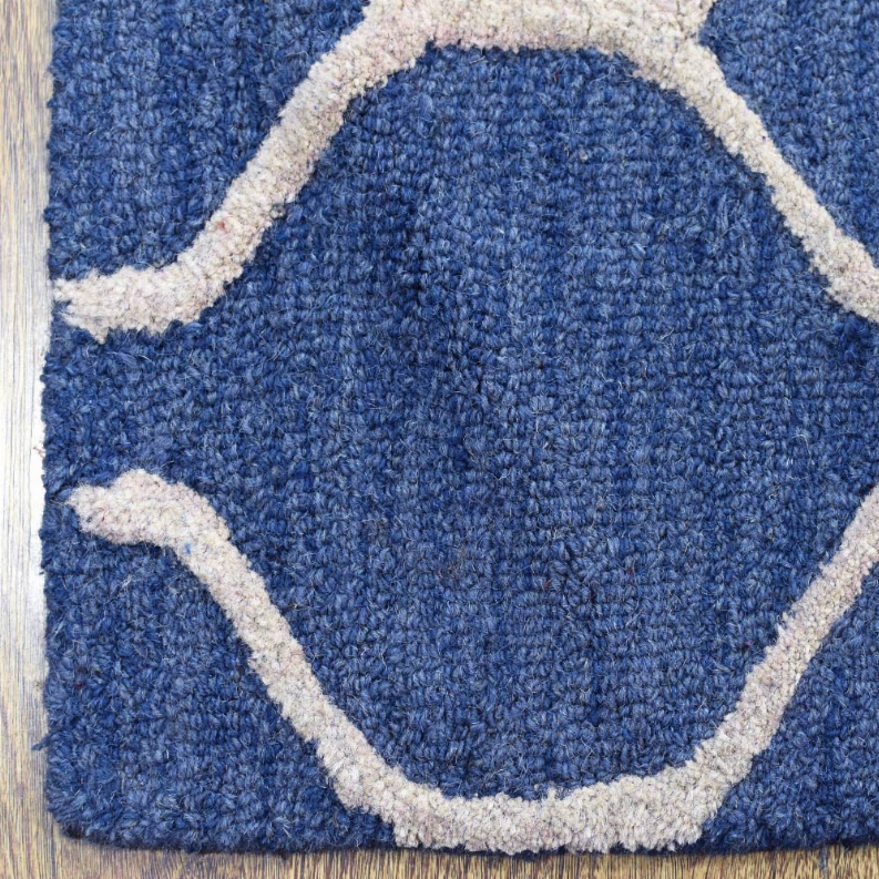Blue wool runner rug close-up: white outlined geometric medallion pattern.